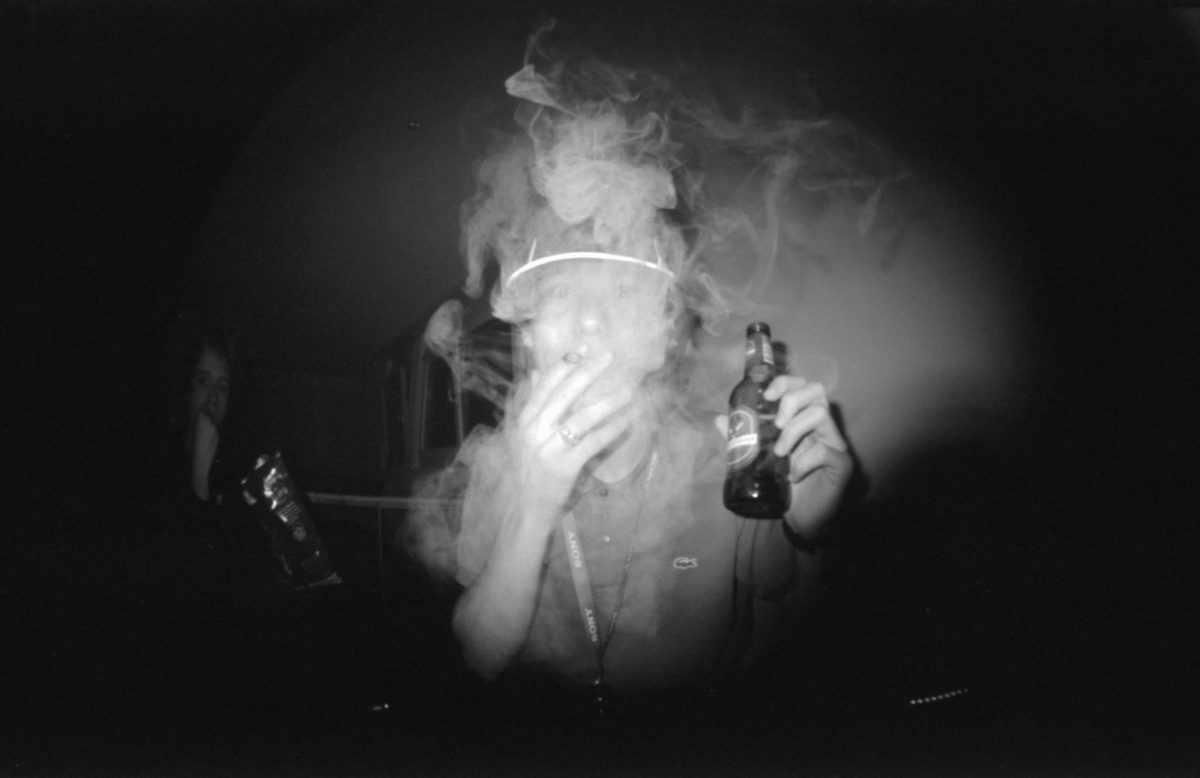 grayscale photo of man smoking cigarette